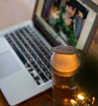 clear glass bottle beside macbook pro